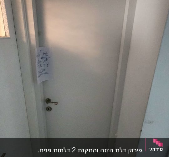 דלת לבנה עם ידית מתכת ופתק תלוי